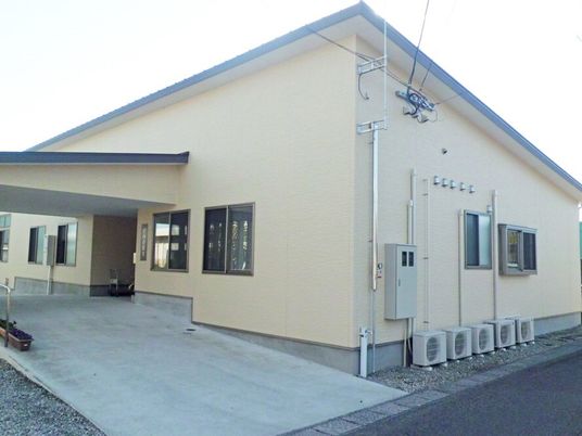 車いす用のスロープと雨除けのひさしがついた施設の外観写真