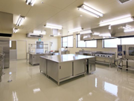 ステンレス製のキッチン用品が並んでいる施設内のキッチンの様子。明るい雰囲気の施設内のキッチン