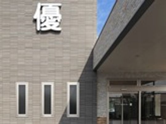 住宅型ホーム優の外観写真。縦に長い窓が並ぶモダンなデザインの外観