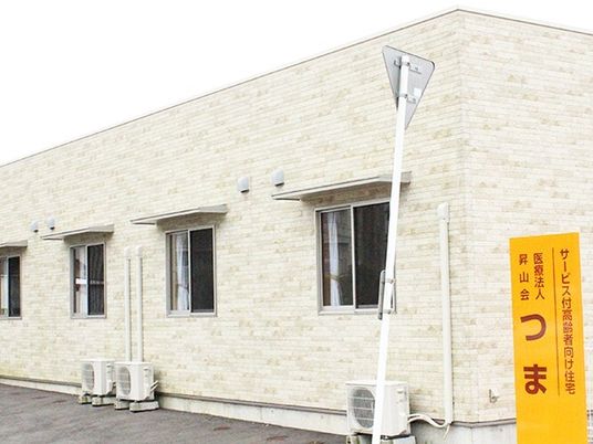 レンガ調の外壁はアイボリー系の色で、平屋建て。窓には小さな屋根があり、館銘板も設置されている。