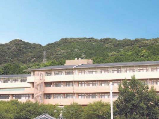 山に囲まれた環境のケアハウス桜の苑の様子。建物の向こう側に山がある様子