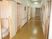 まっすぐな廊下は幅が広く、両サイドに手すりと居室のドアがあり、手前にはトイレが付いていてドアが開けられている。