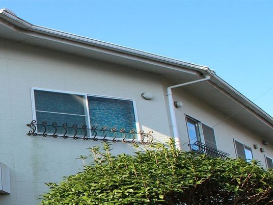 三角屋根の付いた2階建ての建物の2階部分を一部撮影した画像。