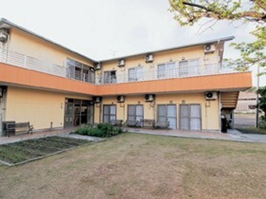 ２階建ての建物はエル字型で敷地内には菜園や庭があり、2階部分にはベランダがある。