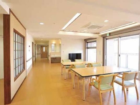 木製の4人掛けのテーブルが並ぶ食堂には大きな窓が付き、左奥には廊下が続いている。