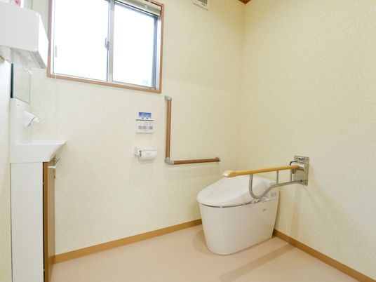 得る自他他の手すりと固定式の手すりがついている施設内のトイレ