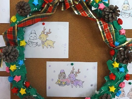 クリスマス会用の飾りつけ、クリスマスカード。リースが周りに飾られている