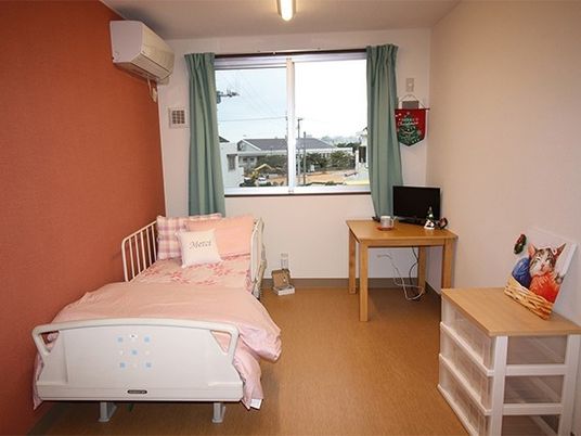 ひとりで部屋でくつろいでいる男性。ホワイトを基調とした部屋で明るい様子が分かる