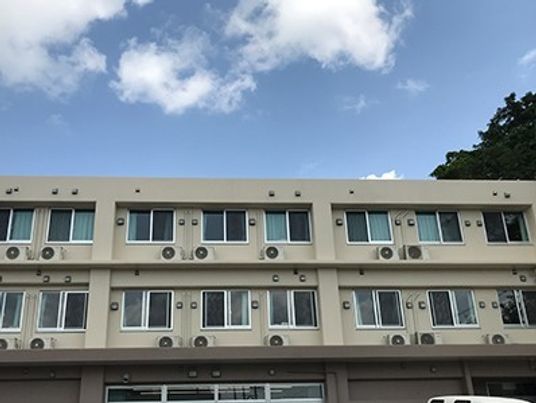 青空が広がっている写真。鉄骨造の建物の外観が写っている