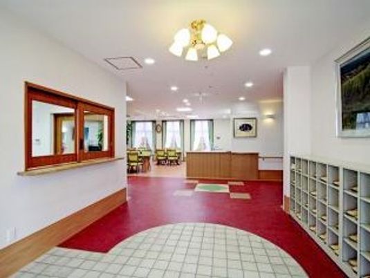 赤と白の鮮やかな色使いが印象的なエントランス。段差がなく安全に移動できる。