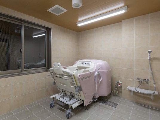座ったまま入浴できる機械浴が設置された浴室には個浴やシャワーも完備され、大きな窓も付いている。