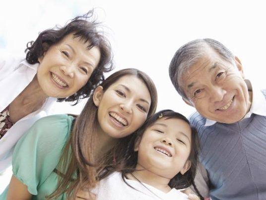 カメラに顔を向けて微笑んでいる祖父母と娘、孫が出かけた時の写真