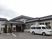2階建ての建物の前にはホームの名前が入った福祉車両がある。玄関には長い屋根が付き、雨をしのげる。