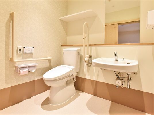 トイレには手すりが両サイドにつき、呼び出しボタンもある。広く介助もスムーズにできる設計。