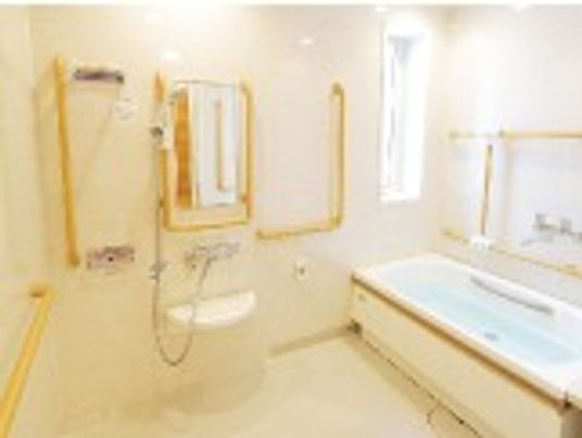 白を基調とした浴室はシンプルで清潔感がある。浴槽は一般家庭と変わらないサイズで手すりが設置されている。