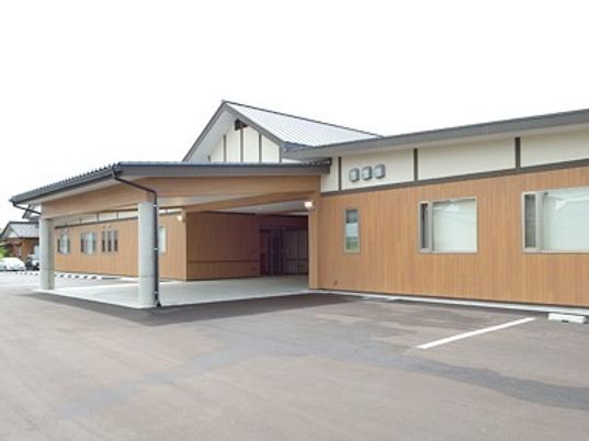 三角屋根が付いた和風の建物。敷地内には広い駐車スペースもある。