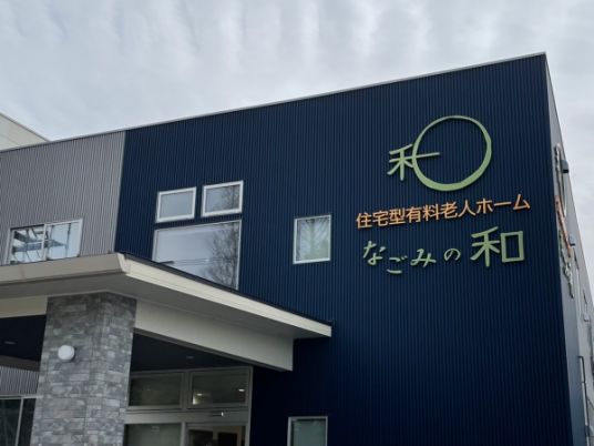 紺色と細いストライプの外壁の2階建て有料老人ホーム