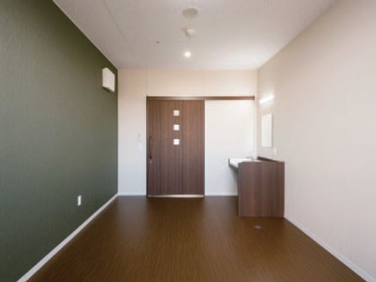 洗面所が付いたシンプルな造り。居室はダークブラウンとダークグリーンでまとめられている。