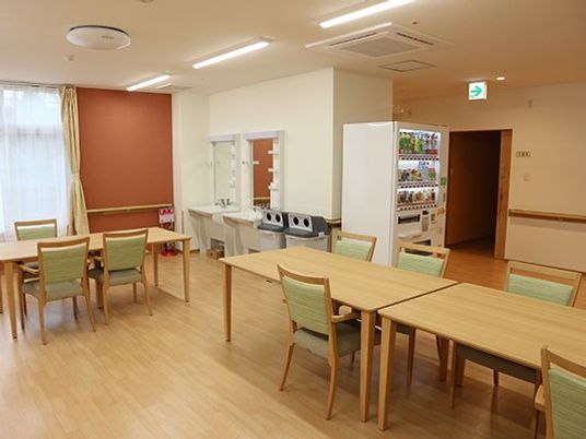 フローリングの食堂にはダイニングテーブルが複数置かれ、自動販売機もついている。
