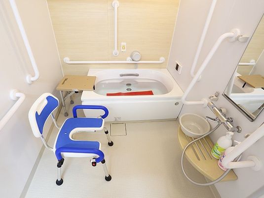 家庭と変わらないサイズの浴槽が設置された浴室には、手すりやシャワーチェアや滑り止めマットなどが用意されている。