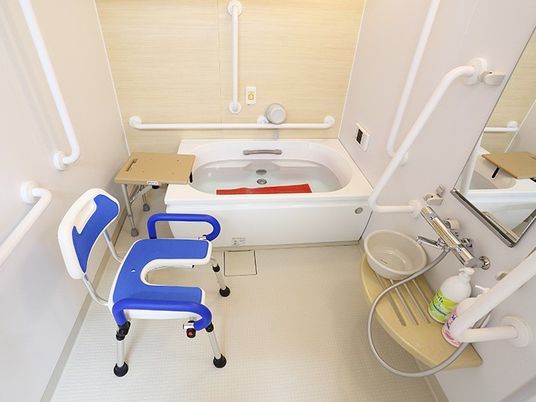 家庭と変わらないサイズの浴槽が設置された浴室には、手すりやシャワーチェアや滑り止めマットなどが用意されている。