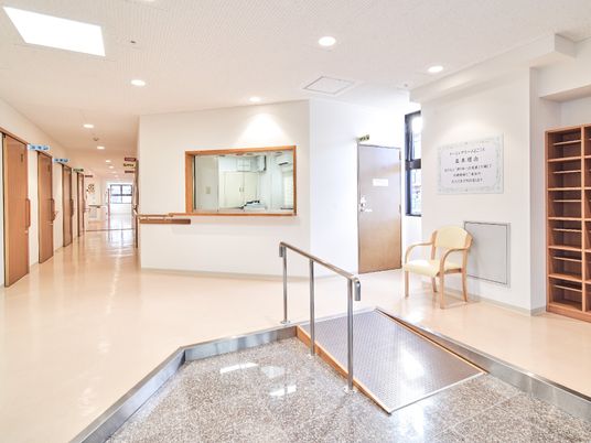 施設内のエントランス部分。車いす用のスロープとげた箱などが写っている