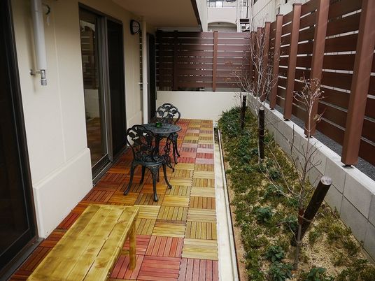 テーブルセットやベンチが置かれたテラスには木や花も植えられ、共有スペースから出入りができる。