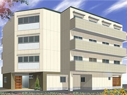 ４階建ての建物はベージュで落ち着いた雰囲気。各フロアにベランダがあり、駐車場も付いている。