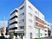 ５階建ての建物。白を基調とした清潔感のある外観で、すぐそばには広い駐車場もある。