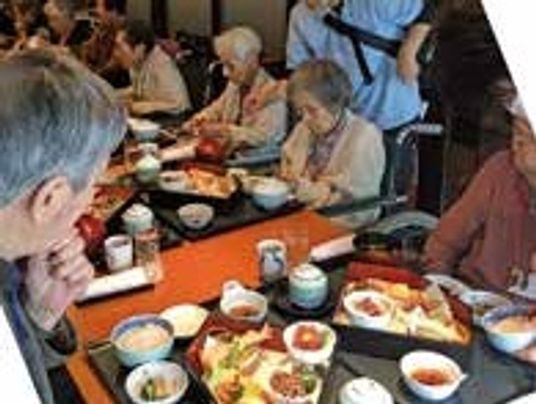 食事をしている施設内の一場面。豪華な食事が膳にのって出されている様子