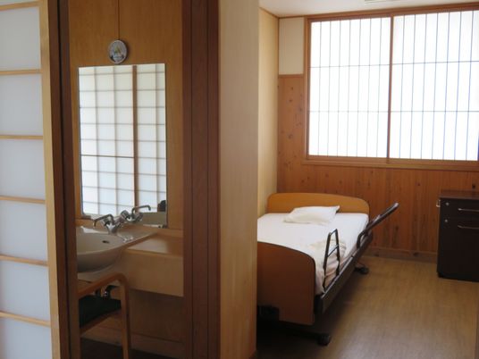 介護用ベッドや洗面所がある居室の窓には障子が付けられ、フローリングですっきりとまとめられている。