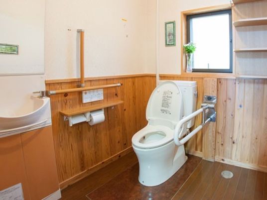 両サイドに手すりが付いたトイレは広く、手洗い場も設置されている。