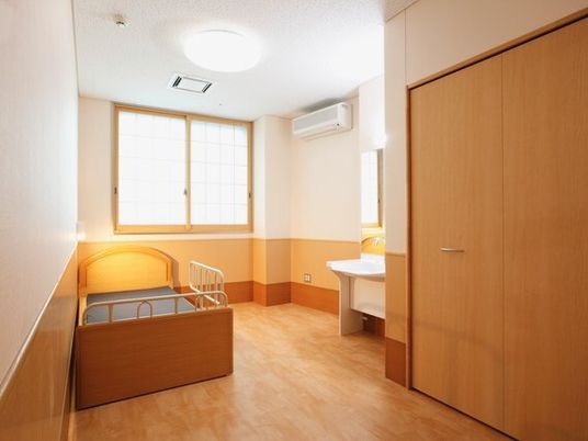 ベッドやクローゼット、洗面所があるフローリングの部屋には障子が付いた窓がある。
