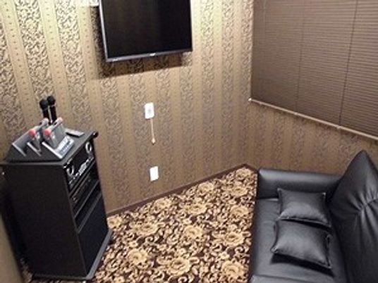 カラオケ機器が置いてある娯楽室の様子。ソファの前にカラオケ機器がある