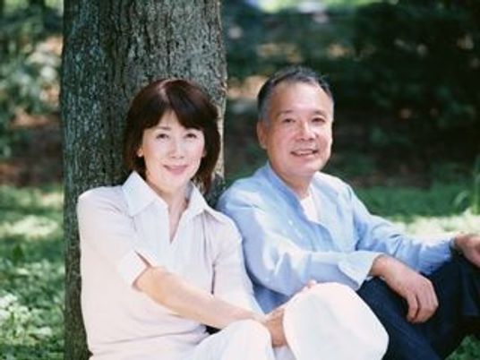 2人でゆったりとほほ笑む老夫婦。外に出て自然を眺めている様子が分かる