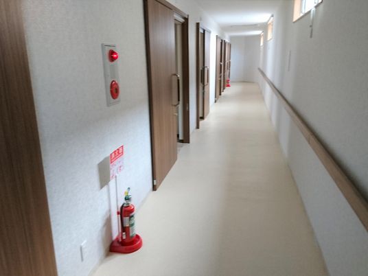 奥に向けて真っ直ぐ伸びた廊下。壁に沿って手すりがあり、歩行の助けとなる。