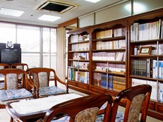 大きな本棚がたくさん並んだ談話室には応接セットやテレビもある。