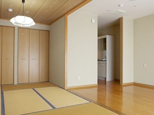 畳敷きの部屋とフローリングの部屋がつながった広めの居室の様子