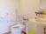 両側に手すりがついた介護仕様のトイレの様子。手前に洗面台がある