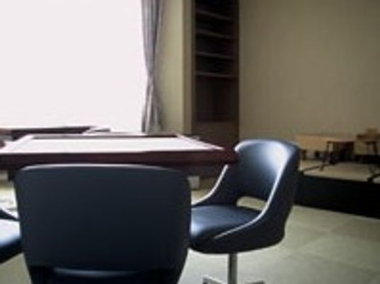 昭和レトロな黒い川のいすとテーブルがある空間。施設内の共有スペース