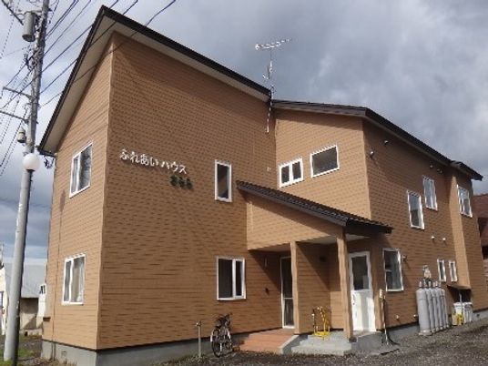 ブラウンを基調とした２階建ての建物は三角屋根が付きアットホームな雰囲気となっている。