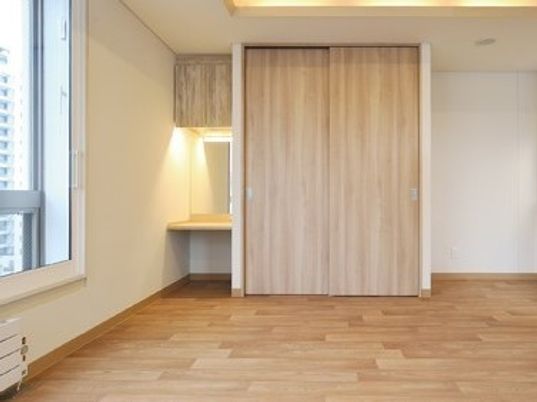 化粧台が付いたフローリングの居室には大型の収納スペースもある。