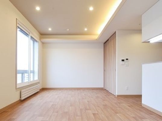 フローリングの居室には大きな窓と対面式のキッチンが付き、パネルヒーターも完備。