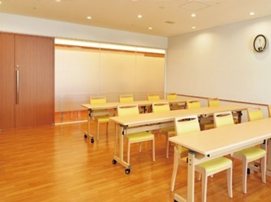 多目的ルームには黄色い椅子がセットされた長机が並べられている。