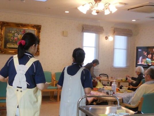 スタッフが施設利用者の食事準備をしている様子。施設内のリビングスペースの様子
