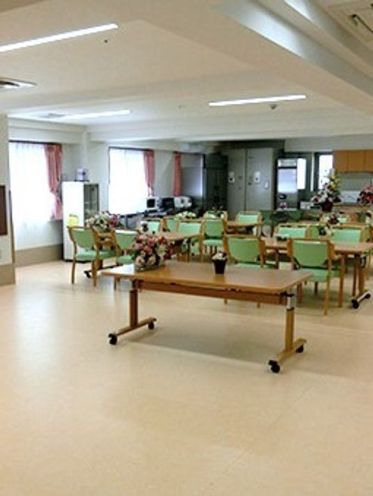 机と椅子のセットがたくさん置かれている施設内の広めのホール