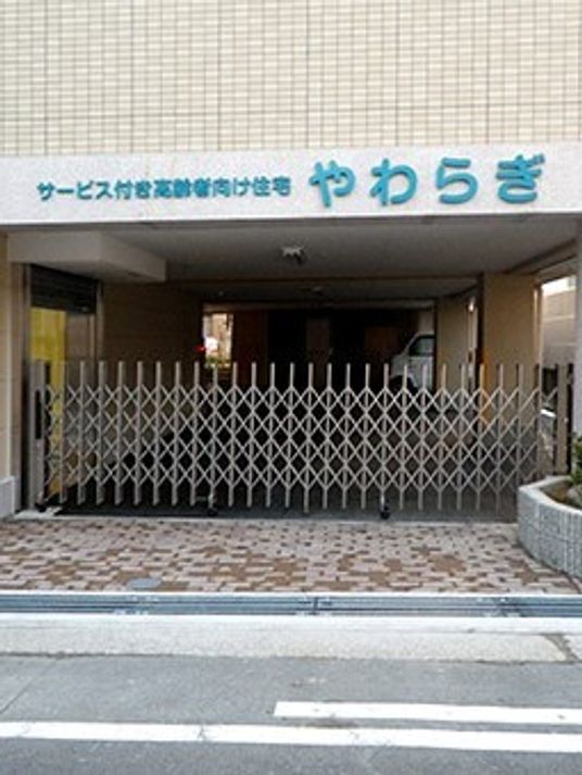 施設の外観・エントランス付近を写したもの。あたたかみある色合いの建物
