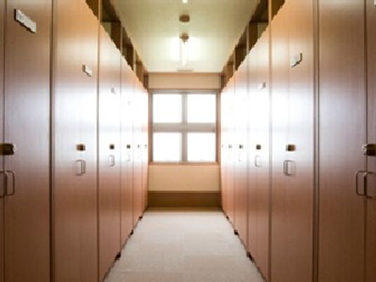 両サイドに天井まで届くトランクが設置されたトランクルーム。部屋の奥には大きな窓が設置されている。