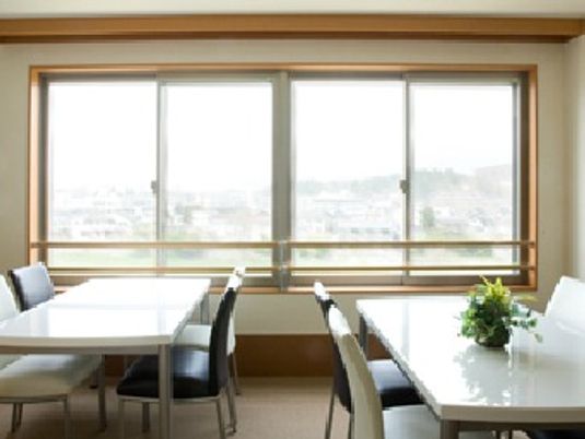 黒いいすと白いいすが2脚ずつ並べられた4人掛けのテーブルが２つ、テーブルの上には花が飾られている。