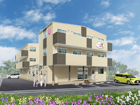 ベージュ系の３階建ての建物のある敷地内には駐車場があり、車が止められている。子連れの女性と高齢者が話している。